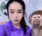 a woman is standing next to a stuffed monkey and taking a selfie .