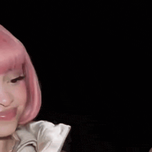 a close up of a woman wearing a pink wig making a funny face .
