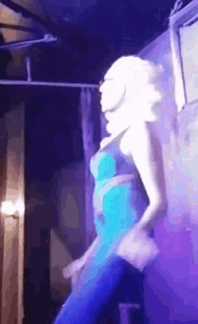 a woman in a blue dress dancing on a stage