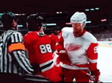 a hockey player with the number 88 on his back is talking to another player