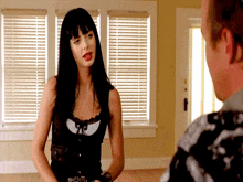a woman in a black top talks to a man in a white shirt