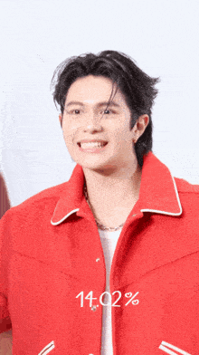 a man in a red jacket is smiling and the time is 14:02 %