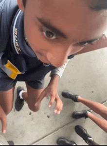 a boy wearing a shirt that says t-shirt is looking at the camera