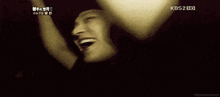 a man is laughing with his hands in the air and his mouth open .