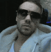 a man wearing sunglasses and a white hoodie