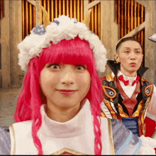 a woman with pink hair wearing a white hat