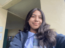 a girl in a school uniform is smiling for a picture