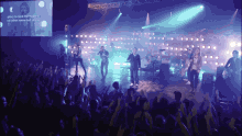 a group of people standing on a stage with a screen behind them that says glory to god the highest