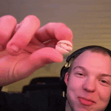 a man wearing headphones is holding a small object in his hand ..