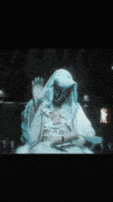 a blurry picture of a man in a white robe waving his hand