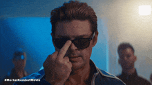 a man wearing sunglasses is giving the middle finger in a #mortalkombat movie