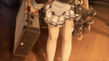 a woman in a maid outfit is holding a suitcase with the letter c on it