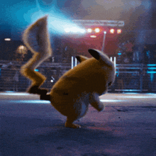 a pikachu standing on its hind legs in front of a crowd