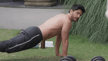 a man without a shirt is doing push ups on the grass