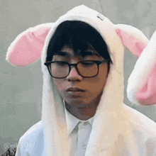 a young man wearing glasses and a bunny hat with ears .