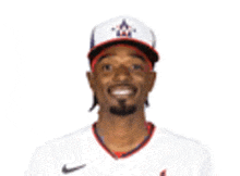 a man wearing a baseball cap and a white jersey is smiling .