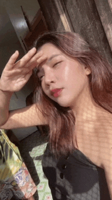 a woman is covering her face from the sun