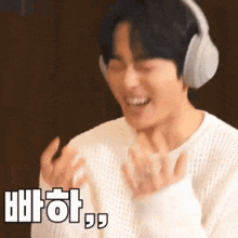 a man wearing headphones is making a funny face with a foreign language behind him