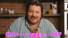 a bearded man with a tattoo on his chest is standing in front of a sign that says happy chev day