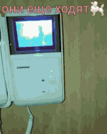 a white commax telephone with a small screen