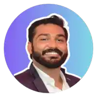 a man with a beard is smiling and wearing a suit