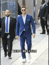 a man in a blue suit is walking down a sidewalk with ruh-u revanim written on the bottom