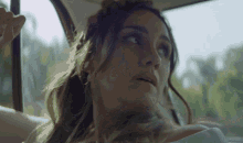 a woman in a white dress is looking out the window of a car