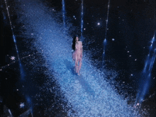 a woman in a pink dress is standing in a field of snow