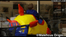 a boy is riding a toy car with the words maleficus origin on the bottom