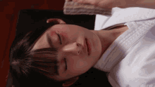 a girl with a red spot on her face is laying down