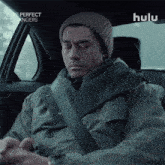 a man is sitting in a car with hulu written on the bottom
