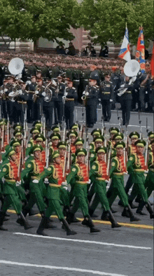 a parade of soldiers marching down a street with a band in the background