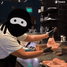 a cartoon of a ninja holding a piece of meat with the word tokeo on the bottom