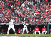 a baseball player getting ready to swing his bat in front of a crowd that is watching