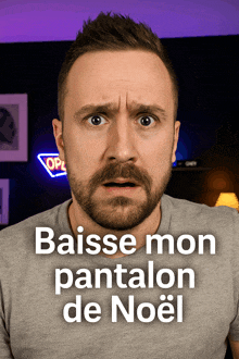 a man with a beard is looking at the camera with the words baisse mon pantalon de noel below him