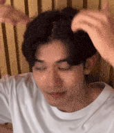 a close up of a man 's face with his eyes closed and his hair being brushed .
