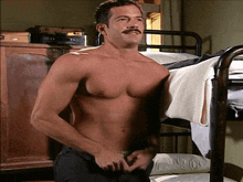 a shirtless man with a mustache is standing in a bedroom next to a bunk bed