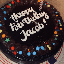 a chocolate birthday cake for jacob with sprinkles and a candle