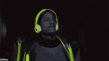 a man wearing neon yellow headphones is dancing