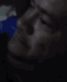 a close up of a man 's face in a dark room