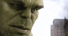 a close up of hulk 's face with a city in the background