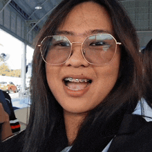 a girl with braces on her teeth wearing glasses
