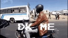 a man is riding a motorcycle down a street with a bus in the background and the words " dx me " on the bottom