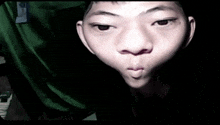 a close up of a person 's face with a green shirt that says g on it