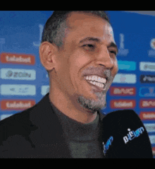 a man with a beard is smiling while wearing a microphone that says ' diego ' on it ..