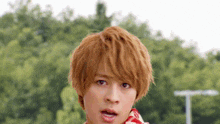 a young man with a scarf around his neck looks surprised