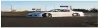 a white car is driving down a road with a sign that says ' a ' on it