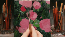 a painting of pink flowers is being painted on a small canvas