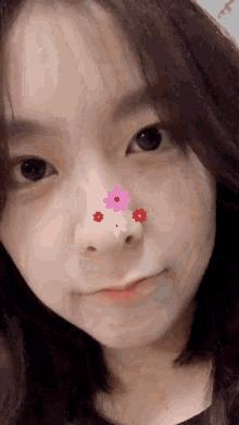 a young girl with flowers on her nose looks at the camera
