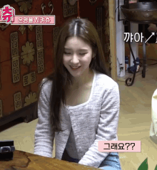 a girl sitting at a table with a sign that says ' ? '